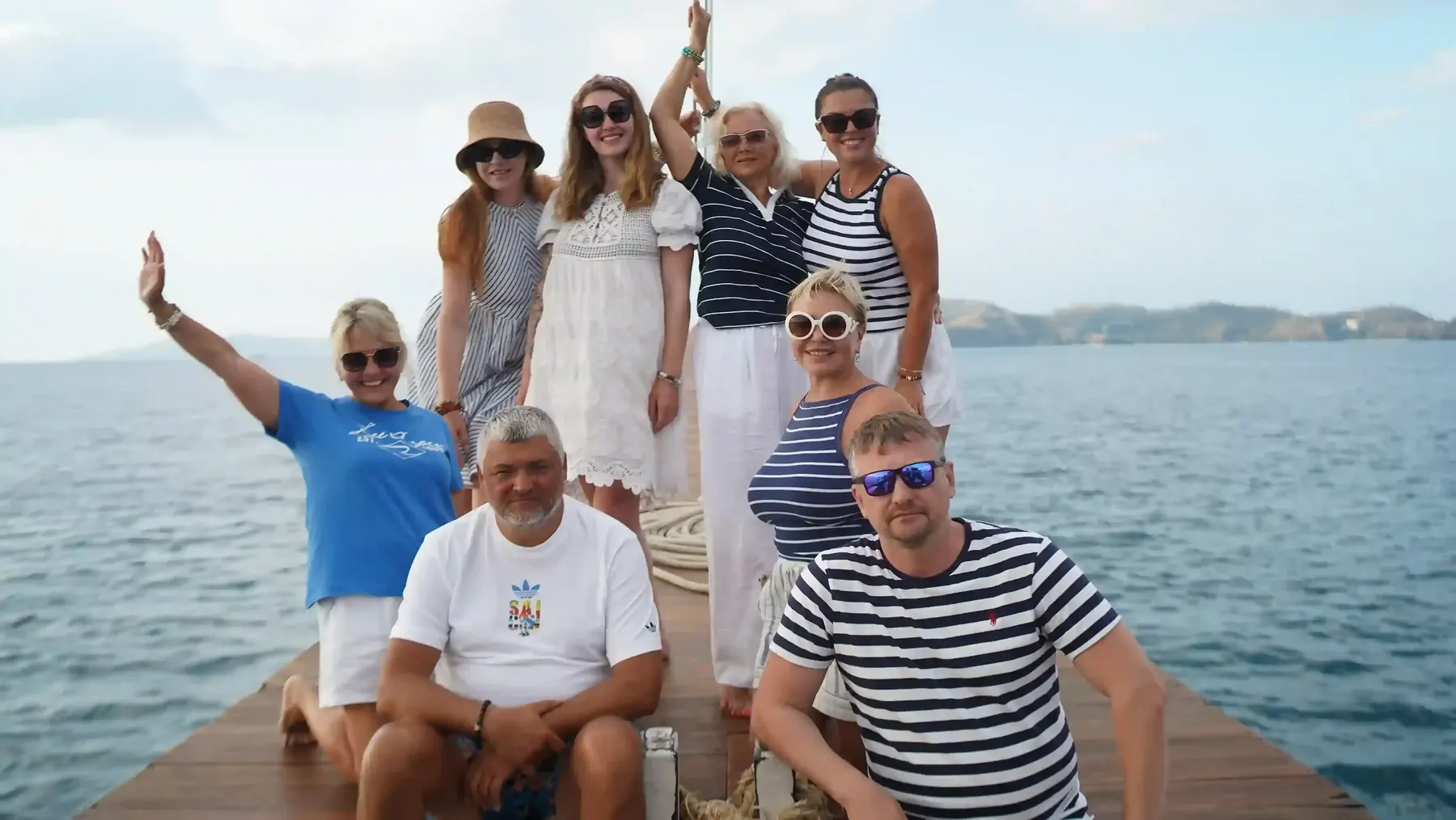 Group of guests smiling on the deck of a yacht
