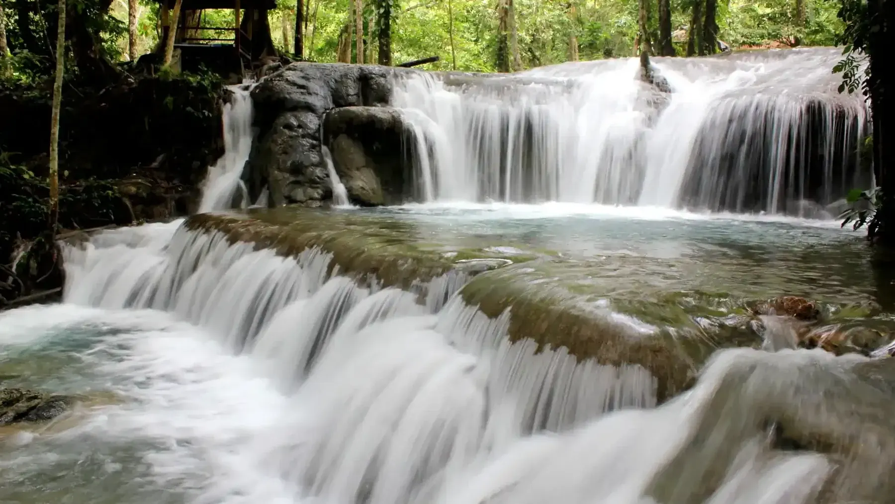 Multi-tiered waterfall over limestone in the jungle