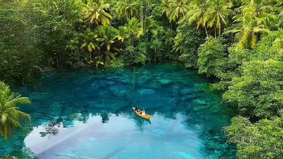 Aerial view of a village on the shore and a hidden lake in the rainforest